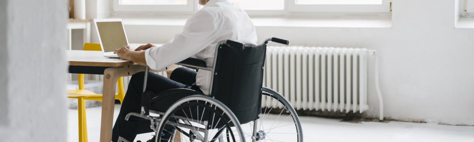 Handicapped manager in a wheelchair, working in office